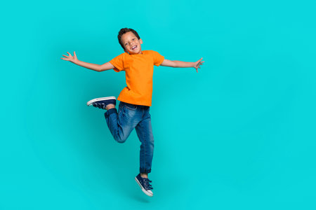 Full length photo of satisfied boy dressed stylish orange clothes rejoice lesson finish isolated on...
