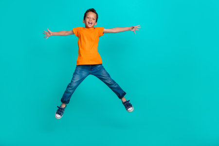 Full length photo of joyful glad satisfied boy dressed stylish orange rejoice holiday weekend break...