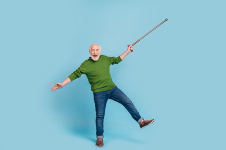 Full size portrait of overjoyed satisfied funny granddad hold stick have good mood isolated on blue color backgroundの写真素材