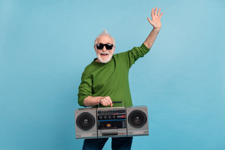 Portrait of funny grandparent have fun hold vintage boombox good mood isolated on blue color...