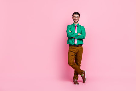 Photo of charming confident guy wear green shirt spectacles arms folded empty space isolated pink color backgroundの写真素材