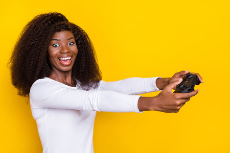 Profile photo of crazy cheerful person hands hold controller enjoy play games isolated on yellow color backgroundの写真素材