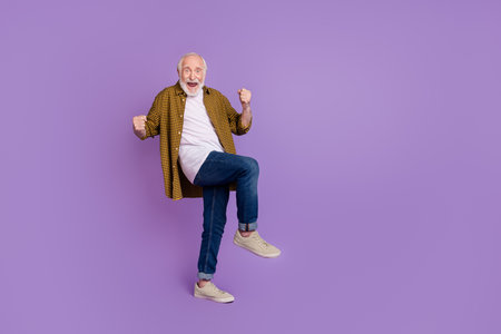 Full size photo of excited granddad white hair achieve goal yell wear stylish yellow plaid shirt isolated on lilac violet color backgroundの写真素材