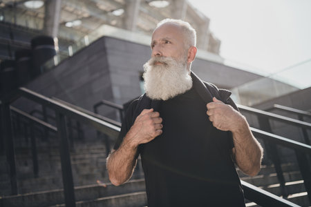 Portrait of attractive virile sportive dreamy grey-haired man sprinter doing physical work out self development outdoorsの写真素材