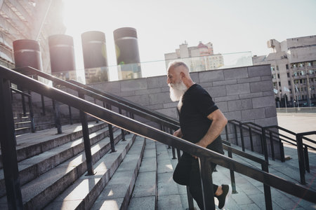 Photo of focused concentrated sportive man run rush stairs endurance warm-up wear t-shirt urban town...
