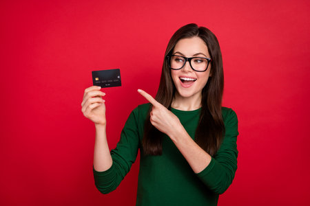 Photo of impressed brunette ceo lady index look card wear spectacles green shirt isolated on red...