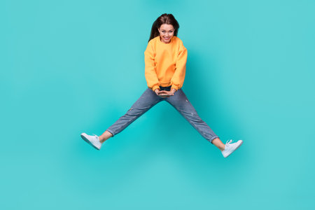 Full body size photo of young attractive pretty nice woman wear stylish outfit dance jump air good day period isolated on cyan color backgroundの写真素材