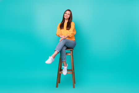 Full body size photo of young adorable gorgeous nice woman sitting chair restaurant positive relax rest business owner isolated on cyan color backgroundの写真素材
