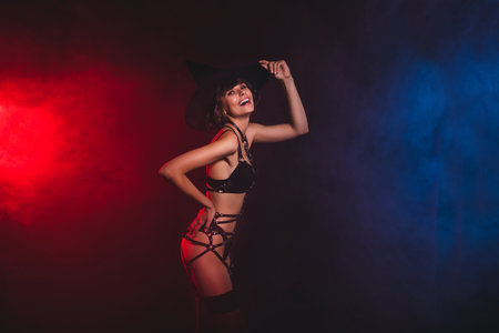 Profile side view portrait of attractive chic cheerful trendy girl touching cap posing isolated over blue light color backgroundの写真素材