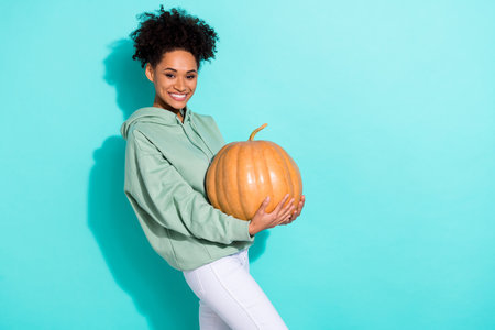 Profile photo of cheerful nice person hands hold large pumpkin empty space isolated on shine teal color backgroundの写真素材