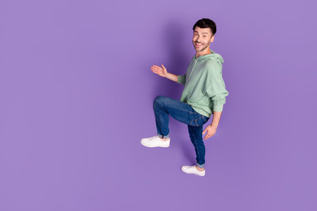 Full size above view photo of satisfied glad person walk climb empty space stairs isolated on purple color backgroundの写真素材