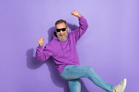 Portrait of retired handsome optimistic lucky man dressed purple hoodie win lottery celebrate...