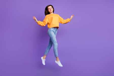 Full body size photo of millennial cute girl flying air trampoline jumping positive smiling advert...