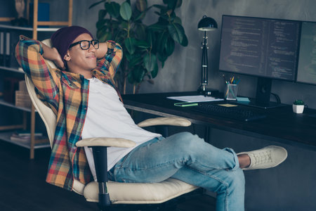 Profile portrait of peaceful positive web designer sit chair hands behind head take nap break loft office indoorsの写真素材