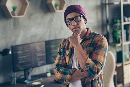 Photo of cool ponder programmer wear spectacles hat thinking debagging program indoors workplace workshop homeの写真素材