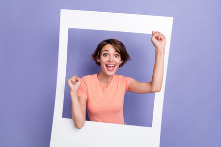 Photo of positive satisfied surprised lady raise hand fist rejoice sale shopping yelling yes isolated on purple color backgroundの写真素材