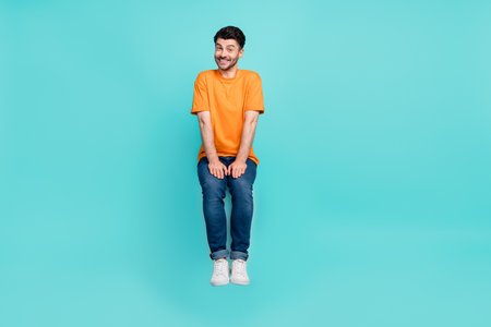 Full size photo of positive guy levitating sitting invisible stool isolated on cyan color background