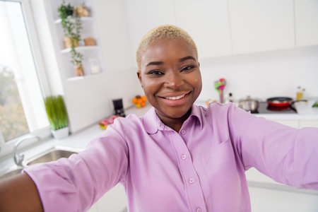 Photo of cheerful friendly girl make selfie recording video toothy smile enjoy free time weekend indoorsの写真素材