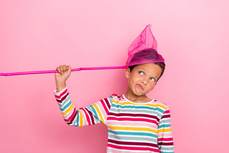 Photo of minded cute boy striped pullover look empty space creative plan idea hmm consider isolated on pink color backgroundの写真素材