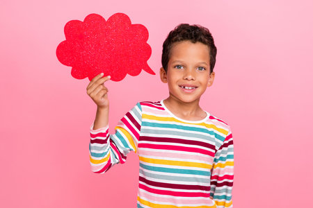 Portrait of attractive cheerful cute boy wear striped pullover outfit hold shiny cloud empty blank...