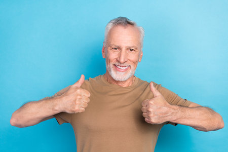 Portrait of positive cheerful muscular man dressed pastel clothes satisfied whitening procedure...