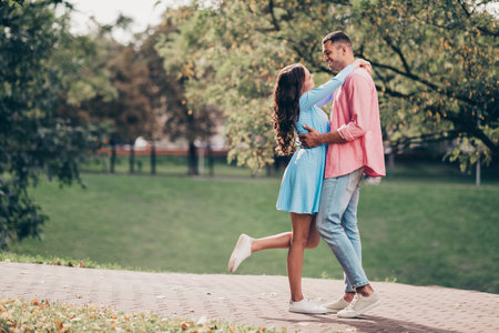 Photo of funny adorable young husband wife dressed summer clothes embracing outdoors backyardの写真素材