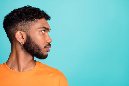 Close up profile side photo of serious confident man wear orange clothes satisfied hairdo look empty space isolated cyan color backgroundの写真素材