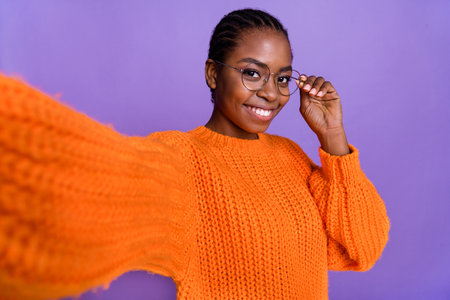Portrait of pretty cheerful lady take selfie hand touch eyeglasses beaming smile isolated on violet color backgroundの写真素材