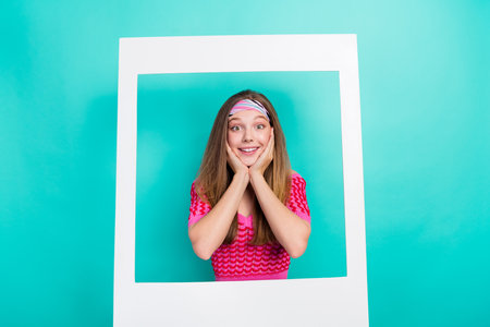 Photo of dreamy school girl dressed pink crop top arms hands cheeks cheekbones photographing frame...