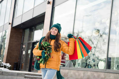 Photo of charming dreamy schoolgirl wear windbreaker jacket buying xmas gifts decorations outside urban city street