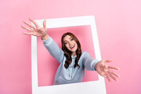 Photo of positive pretty girl raise arms invite welcome camera you isolated on pink color backgroundの写真素材