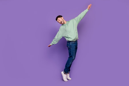 Full length photo of young handsome bachelor man dancing tiptoe carefree enjoy his life weekend...