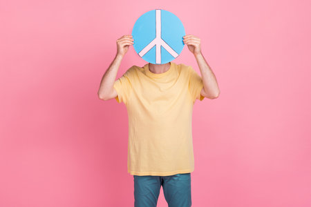 Photo of funny person boy close hide head behind hippie sign demonstrate symbol want peace isolated on pink color backgroundの写真素材
