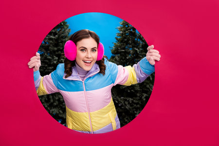 Photo of optimistic adorable lady peek out hole window empty space enjoy snowy weather park outdoors...