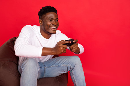 Photo of funky cheerful guy dressed white shirt enjoying looking empty space isolated red color...