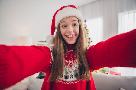 Photo of funky cheerful girl take selfie tongue lick teeth beaming smile festive christmastime indoorsの写真素材
