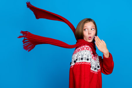 Photo of dreamy impressed school girl wear red xmas ornament sweater looking back empty space isolated blue color backgroundの写真素材