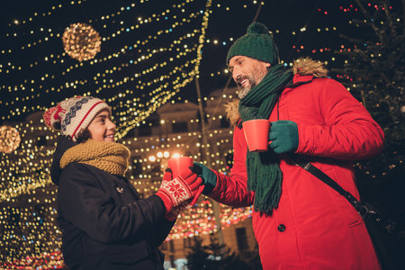 Portrait of attractive cheerful people adopted foster son single dad visiting festal eve fair drinking latte cacao city urban outdoorsの写真素材