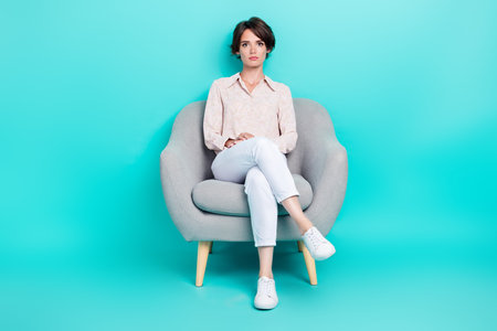 Full length photo of adorable serious lady sit cozy chair conduct conference meeting isolated on aquamarine color backgroundの写真素材
