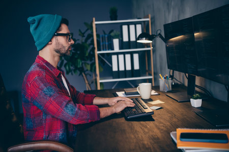 Photo of pensive serious programmer wear spectacles creating software modern device indoors workplace workshop homeの写真素材