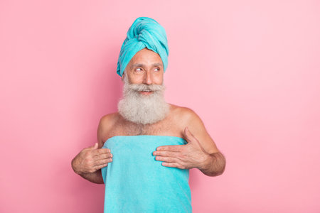 Photo of senior aged male look empty space after bath routine isolated on pastel color backgroundの写真素材