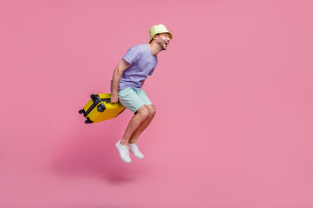 Full size photo of handsome young guy jump look empty space travel agency client dressed trendy blue look isolated on pink color backgroundの写真素材