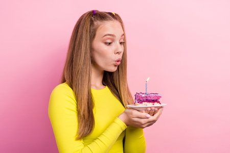 Photo of shiny dreamy schoolgirl wear yellow top holding cake piece plate having birthday wish...