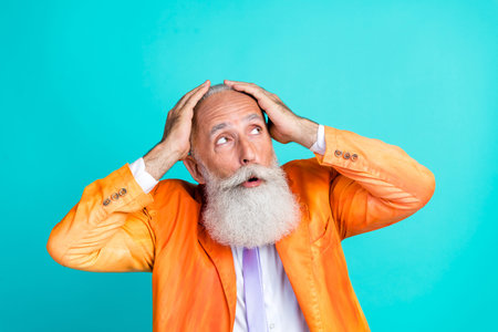 Portrait of shocked impressed man hands touch head look interested empty space isolated on emerald color backgroundの写真素材