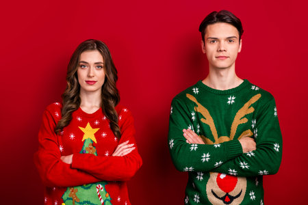 Portrait of two concentrated focused people folded hands calm face isolated on red color backgroundの写真素材