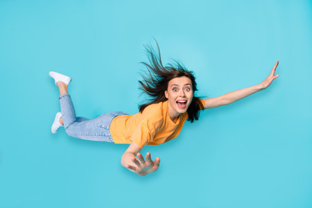Full length photo of astonished girl impressed open new skills can fly hand wings isolated on blue color backgroundの写真素材