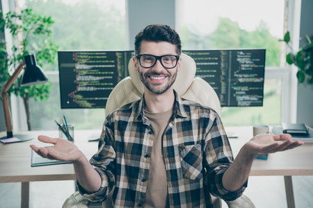Photo of cheerful smiling programmer wear spectacles recording video course modern device indoors workplace workshop homeの写真素材