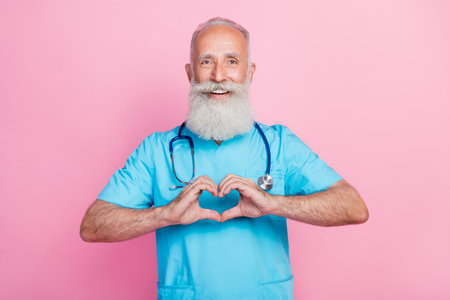 Photo of qualified retired age man doctor make hands heart symbolize cardiac donation isolated on pastel color backgroundの写真素材