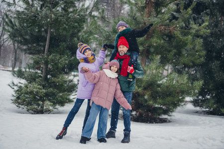 Photo of funky excited husband wife small kid wear windbreaker riding shoulders having fun together outside urban city parkの写真素材