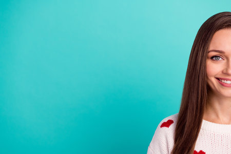 Photo of funky girly girl dressed white pullover smiling half face empty space isolated teal color backgroundの写真素材